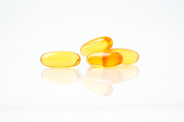 Pile of yellow softgel medical pills, supplement vitamin, isolated over the white background