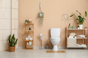 Toilet bowl and shelving units near beige wall in restroom