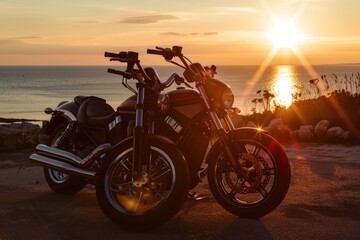 Two motorcycles parked on a coastal road at sunset, with the ocean and setting sun in the background.