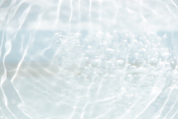 White water with ripples on the surface. Defocus blurred transparent white colored clear calm water surface texture with splashes and bubbles. Water waves with shining pattern texture background.