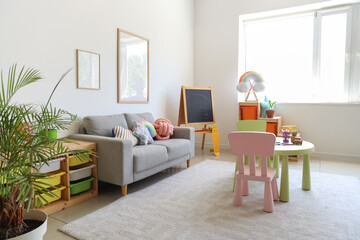 Interior of children's room with sofa, table and chalkboard