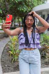 Woman Taking a Selfie with Red Phone in Park