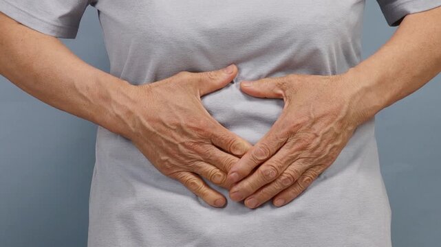 Close up of an elderly person suffering from abdominal pain