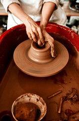 Hands, pottery wheel and woman with clay in workshop and creativity with productivity, hobby and tools. Closeup, entrepreneur or person with equipment, designer and artist with small business or spin