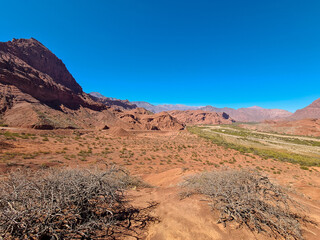 Valley with dry river and stratified sedimentary rocks