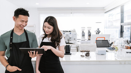 Startup successful small business owner sme boy girl stand with tablet in coffee shop restaurant. Portrait of asian tan man woman barista cafe owner. SME entrepreneur seller business delivery concept