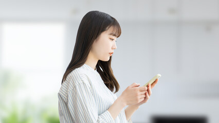 スマホを操作をする若い日本人ビジネスウーマン