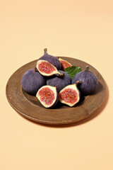 Fresh ripe figs in a wooden bowl on a light background