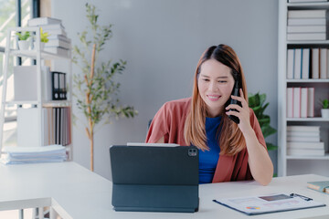 Confident happy young female, business woman leader, professional Asian business woman company manager working on laptop in office sitting at work desk looking at camera, portrait.