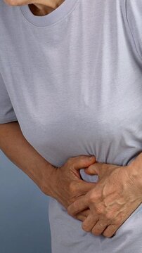 Close up of an elderly person suffering from abdominal pain