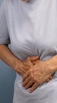 Close up of an elderly person suffering from abdominal pain