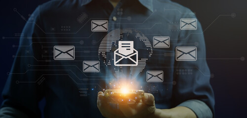 Email marketing concept. Direct selling project in customer list business for email. Businessman holding smartphone to show email icons on virtual screen.