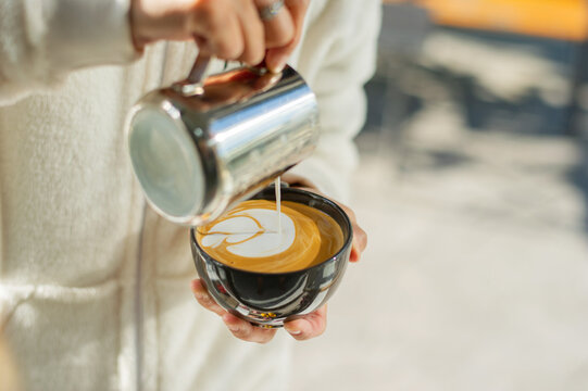 closeup hand doing hot latte art coffee