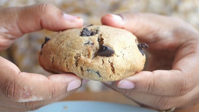  woman hand creaking a chocolate cookie