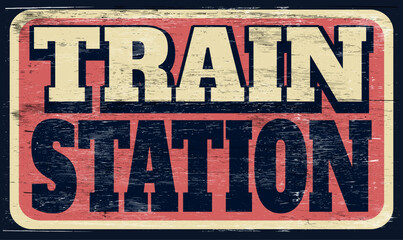 Aged and worn train station sign on wood