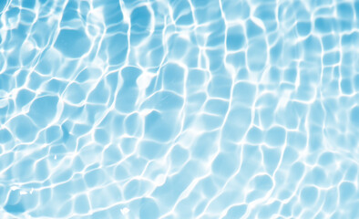 Blue water with ripples on the surface. Defocus blurred transparent blue colored clear calm water surface texture with splashes and bubbles. Water waves with shining pattern texture background.