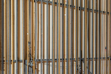 Theater stage rigging with theatrical equipment, lighting, supports, and chains. Photo taken from an elevated position looking across the rigging.	