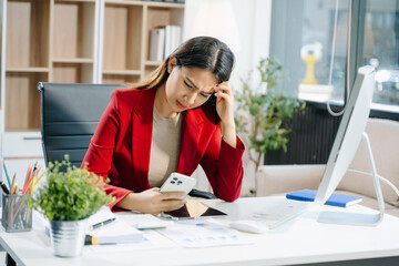 Business woman is stressed, bored, and overthinking from working on a tablet at the office..