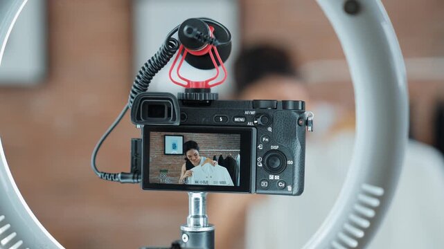 Rear view behide camera screen display woman influencer shoot vlog video review clothes prim social media or blog. Girl with apparel studio lighting for vivancy live streaming marketing recording