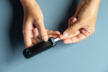 Woman's hands checking diabetes and hyperglycemia with digital blood sugar meter. Healthcare and medical concept	