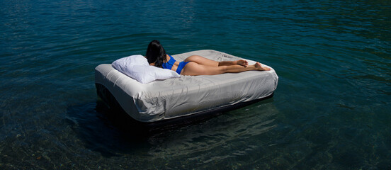 Comfort cozy bed concept. Woman with inflatable mattress in summer water. Sexy woman sleeping or...