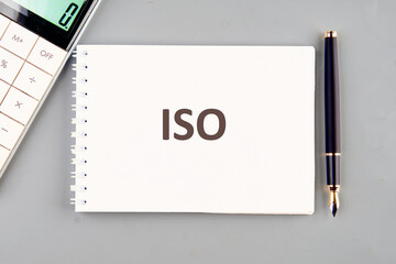 ISO service concept. ISO in a notebook on a gray background