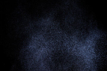 Abstract splashes of water on dark background. Black and blue grunge texture. Light clouds overlay texture on black backdrop.