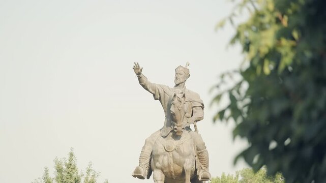 Static shot of the historic Amir Timur Statue in downtown Tashekent Uzbekistan, green trees around, copy space 