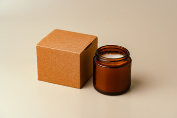 Glass Candle Jar and Cardboard Box on Beige Background
