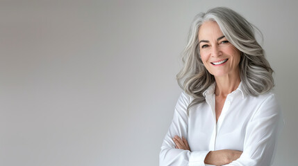 Handsome woman 50s mid age beautiful physically fit well groomed senior model grey hair stylish smiling Healthy face skin care skincare hair care fitness dental off center copy space gray background