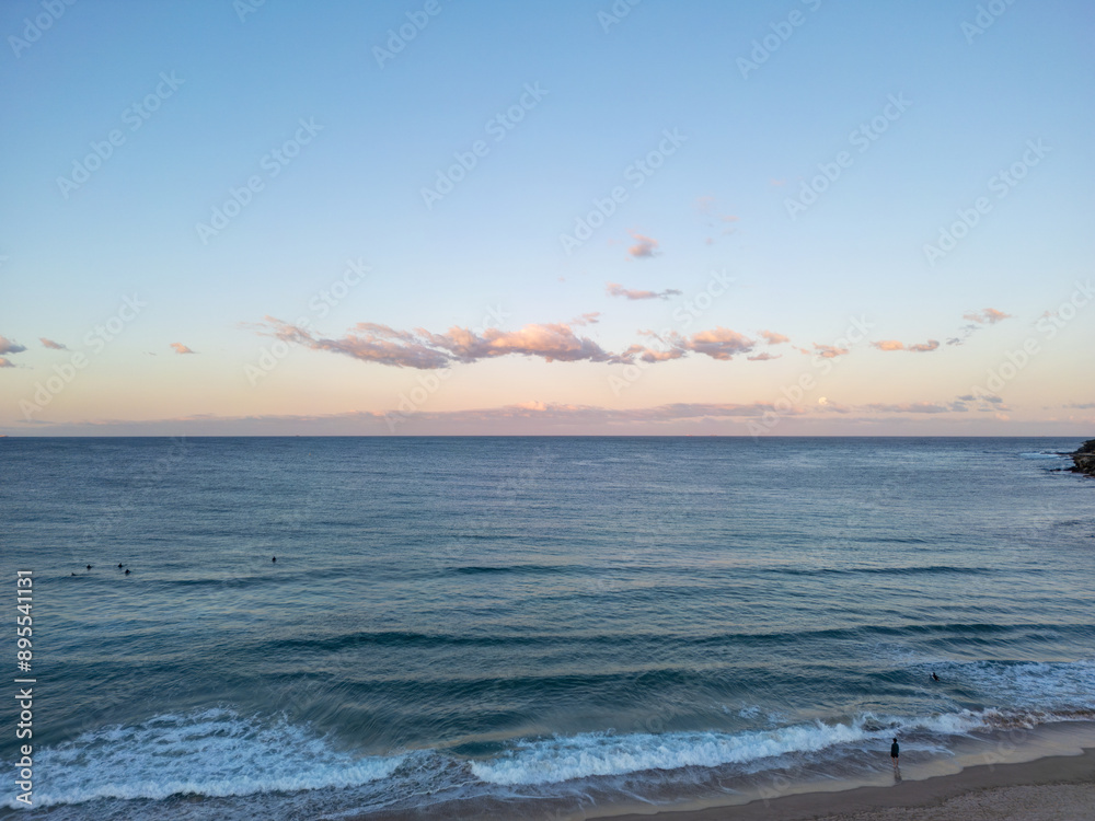 Canvas Prints Aerial drone view sun setting over the beach with silhouettes of people and surfers 