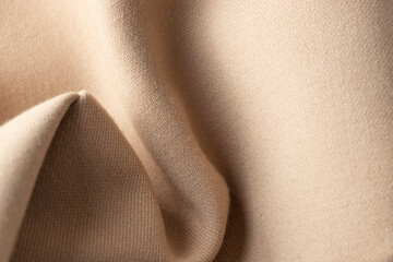 Abstract knitted fabric in neutral beige colour, close up