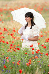 Young woman in love in retro dress and parasol in poppy field