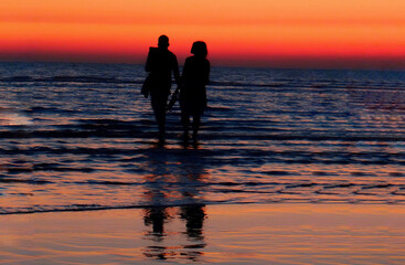 happy couple walking on the beach