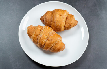 top view of a plate of croissants on dark stone table