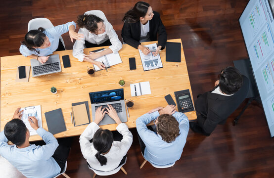 Wide top view project manager planning schedule for business task at meeting room, Gantt chart time line software show on TV. Multi ethnic business people and modern project management. Meticulous