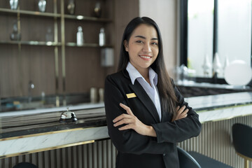 Beautiful asian hotel receptionist in  uniforms at desk in lobby Friendly and welcome staff in hotel reception counter.