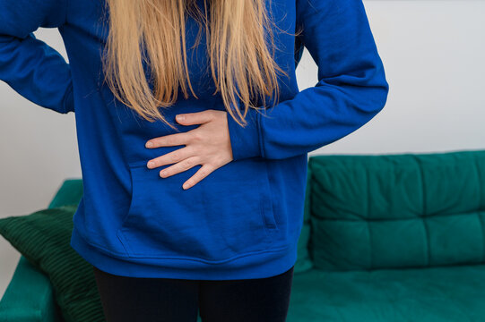 Kobieta trzymająca się za środek swojego brzucha, b&oacute;l 