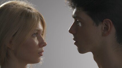 Young man and woman tender lovers faces shot looking at each other, love touching, candid feelings. Love and affection relationships concept.