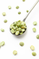 Dry, green peas in iron spoon on white background