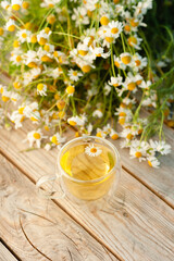A cup of chamomile tea on a wooden table.
