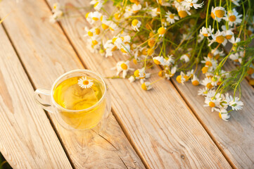 A cup of chamomile tea on a wooden table.