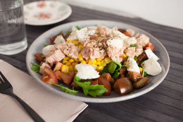 Fish salad with canned tuna and corn, tomatoes and arugula