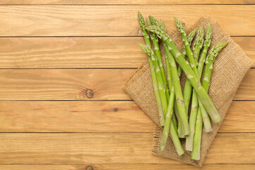 Fresh asparagus on wooden background, top view