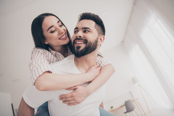 Photo of happy young couple piggyback cuddle move new place enjoy live together new apartment room light house flat indoor