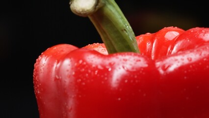 Macrography of a red bell pepper against a sleek black background takes center stage. Each close-up...
