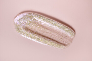 Transparent lip gloss tint with holographic sparkles. Smudged cosmetic product sample