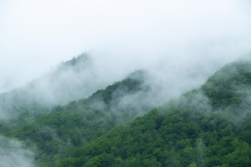 Foggy and snowy mountain view from Mestia village of Svaneti. Magnificent nature of Georgia. Foggy and snowy mountains and hills.