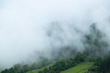 Foggy and snowy mountain view from Mestia village of Svaneti. Magnificent nature of Georgia. Foggy and snowy mountains and hills.