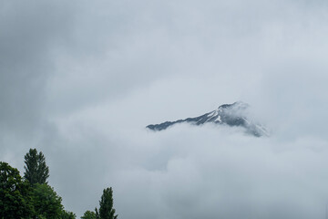 Foggy and snowy mountain view from Mestia village of Svaneti. Magnificent nature of Georgia. Foggy and snowy mountains and hills.